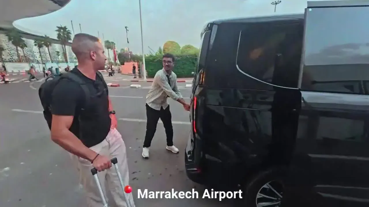 Mohamed welcomes travelers next to the van